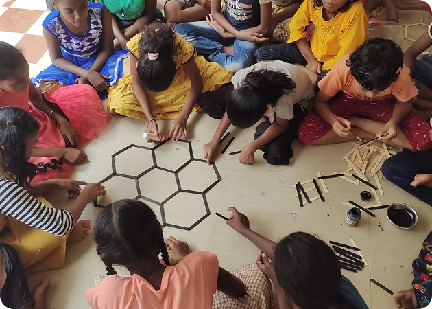 Children collaborate on a hexagonal floor art project